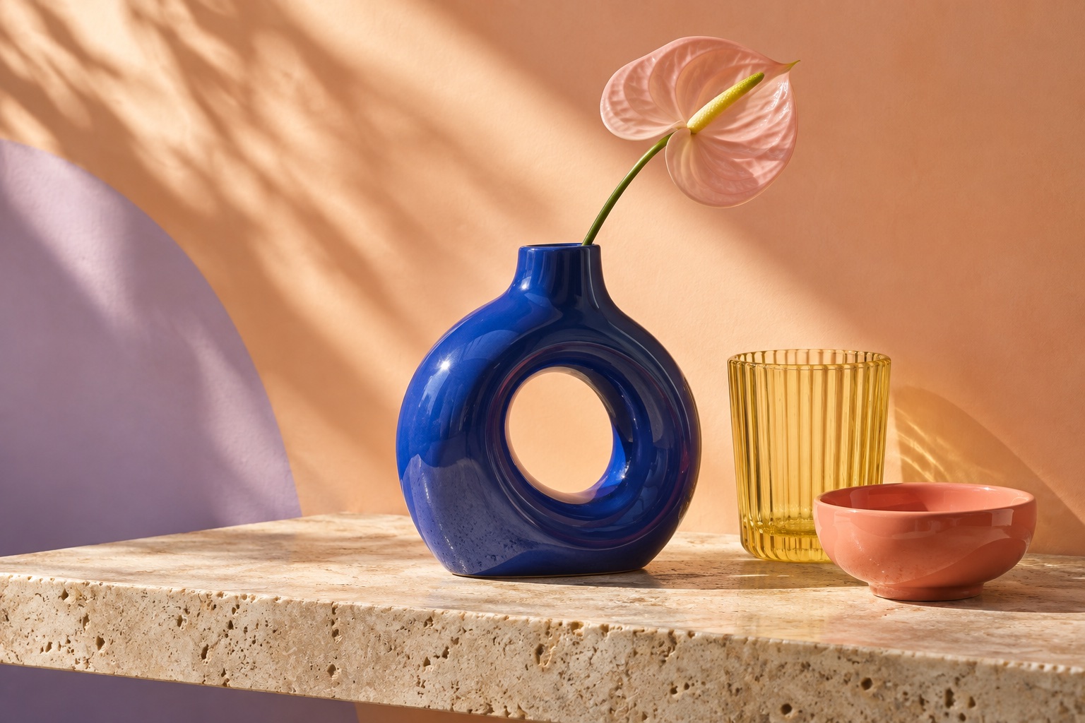 Blue ceramic vase, yellow glass and coral bowl in a colorful homeware storefront concept